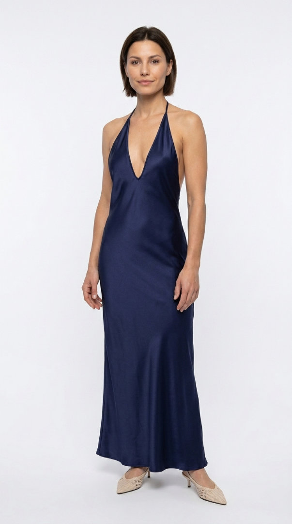Woman in a floor-length navy halter dress with beige heels