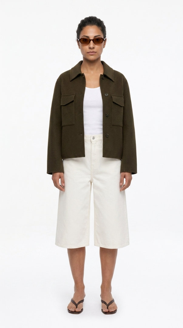 Woman in an olive shacket, white top, wide-leg culottes and sandals